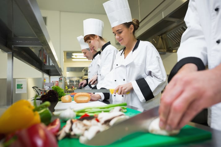 Alunos de culinária estão aprendendo a cortar legumes