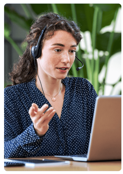 Uma mulher fazendo atendimento telefônico usando headset de frente ao computador.